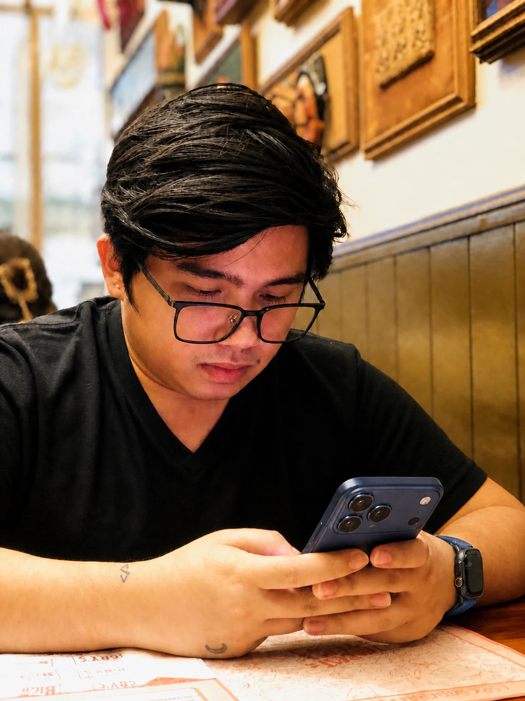 Frail Bongat seated at a restaurant and looking at his phone